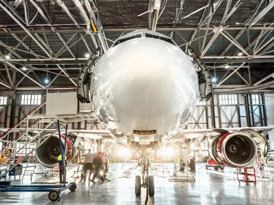 Airliner nose and engines inside a maintenance hangar
